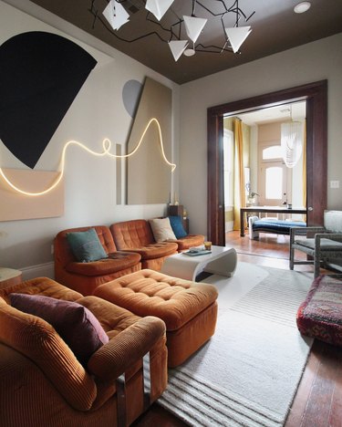 midcentury 70s living room with 3d neon artwork and sculptural chandelier