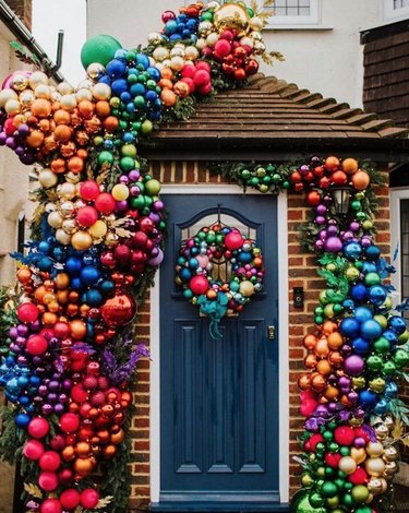 Front porch with colorful Christmas ball decor and wreath.