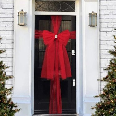 Front door wrapped with red ribbon.