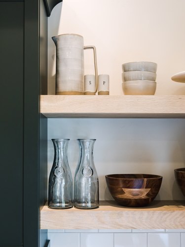 Open shelves with dishes, glasses, bowls, pitcher.