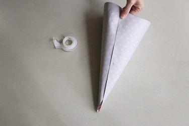 Rolling and taping paper template into cone