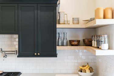 Dark gray cabinets, open shelves, white subway tile.