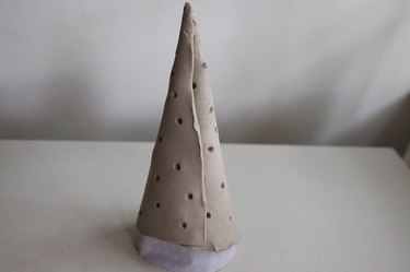 Clay rolled around paper cone and formed into a cone shape