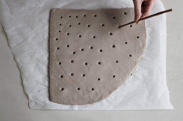Cutting holes out in clay with a paper straw