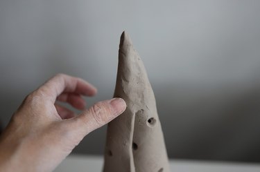 Smoothing seam of clay cone with fingers
