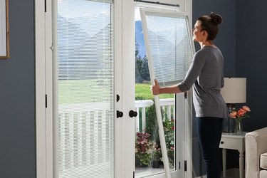 Woman Installing Add-On Blinds With Tempered Safety Glass Panel