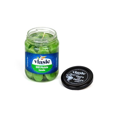 A Vlasic Dill Pickle candle car with the lid off on a white background.