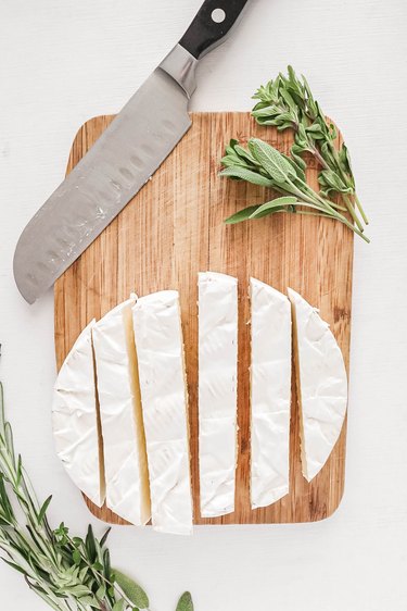 Sliced brie on a wood cutting board