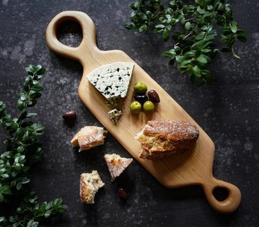 wood serving board with cheese bread and olives