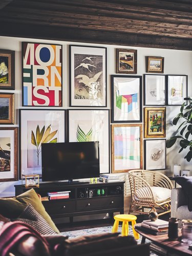 A TV area featuring a gallery wall that has framed prints in various sizes and colors.