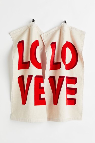 Two white guest towels that say LOVE in a large red font.