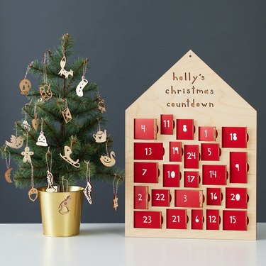 wood advent calendar with small christmas tree decorated with wood ornaments