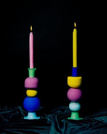 Two colored candlesticks with stacked shapes on a black background.