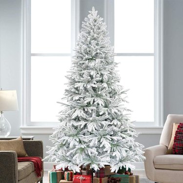 snow-dusted artificial christmas tree in living room