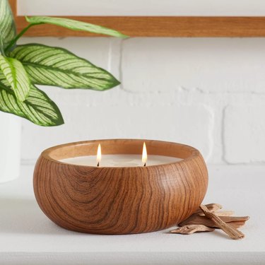 wood candle with two wicks near white wall