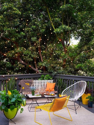 deck surrounded by trees with outdoor lights