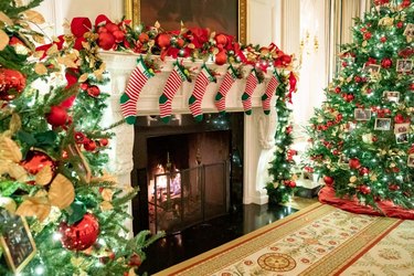 fireplace with stockings near christmas trees in a room in the White House