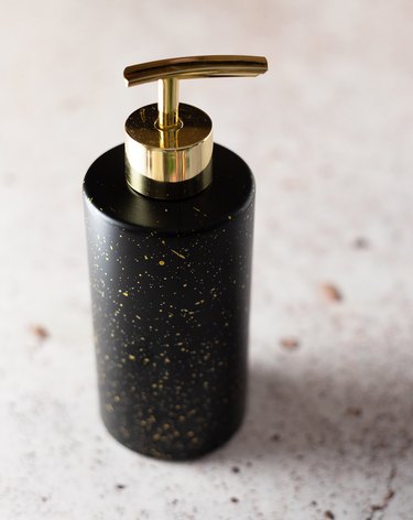 Black soap bottle with gold pump dispenser
