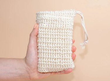 Hand holding a sisal exfoliating soap bag