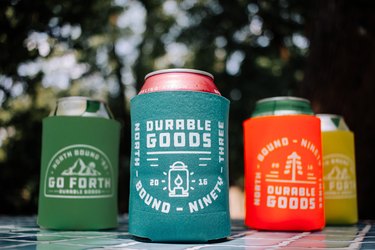 Four cans in green, turquoise, orange, and yellow koozies
