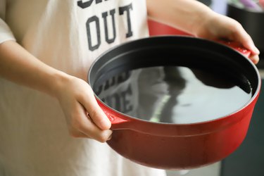 A person holding a red pot
