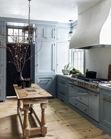 Traditional kitchen with blue cabinets and unique table island