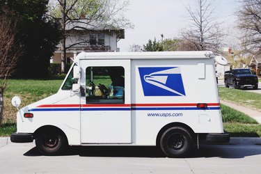 usps mail truck in front of grass