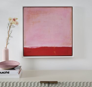 Pink and red painting, vase, flowers, books.