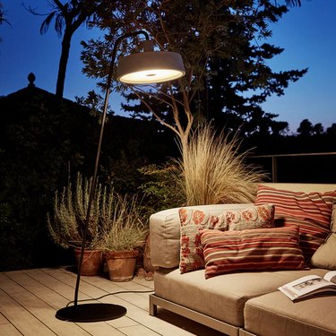outdoor sofa lit by large floor lamp