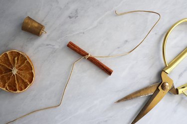 Leather cord tied around center of cinnamon stick