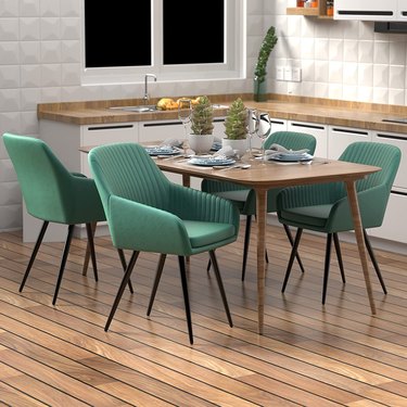green velvet dining chairs around wood table