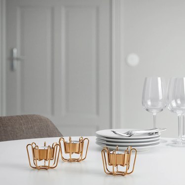 table with dinnerware and three gold candle holders