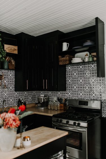 A small black kitchen with bold tile.