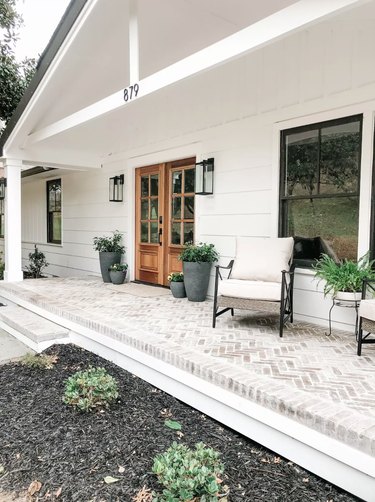 large front porch on farmhouse with brick pavers