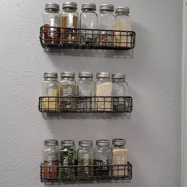 wire baskets mounted to the wall for spice storage