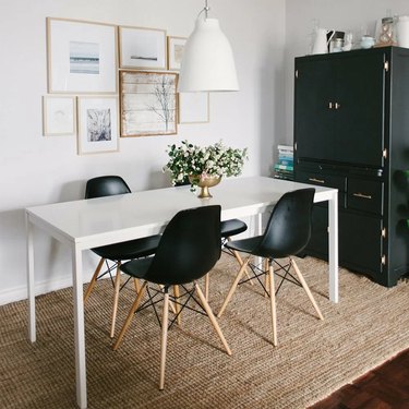 black eames-inspired chairs around white rectangular table