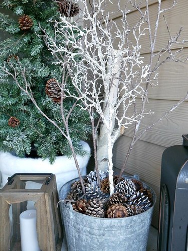 winter front porch with white branch and pine cones