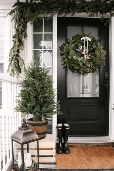 winter front porch with evergreen on crate