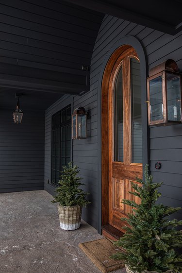 black winter front porch with evergreens