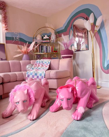 A light pink and Barbie pink panther table in a living room next to a blush pink sectional.