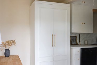 IKEA PAX pantry hack with molding and gold handles in kitchen