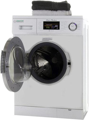 A compact washing machine with folded towels on top