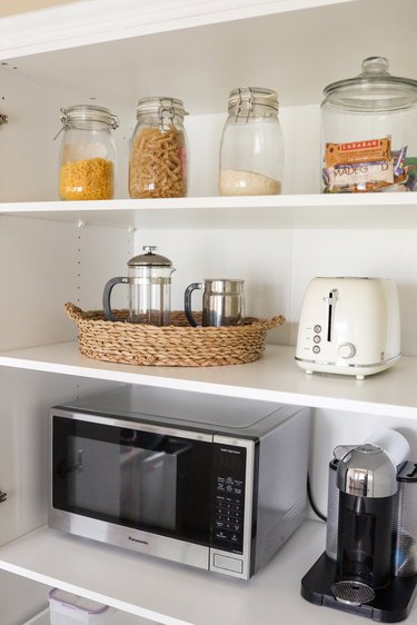 IKEA PAX pantry hack with jars of food, microwave, toaster, and coffee maker