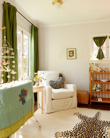nursery with dark green curtains and whimsical leopard rug