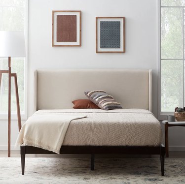 tan upholstered bed in bedroom