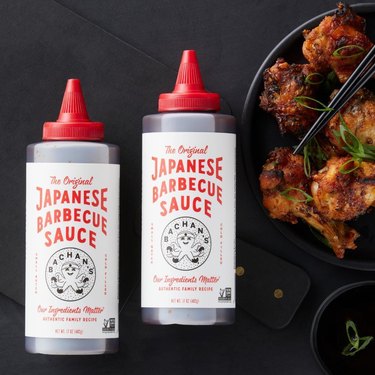 Two bottles of Bachan's Japanese barbecue sauce on dark background