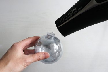 Blowing air into ornament with hair dryer to dry vinegar
