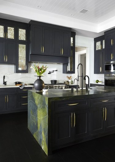 black kitchen island with green marble countertop