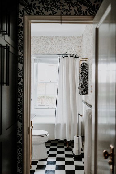 black and white checkered bathroom floor with black and white wallpaper