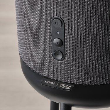 A close-up of the speaker power button and volume controls on IKEA's new black floor lamp speaker.